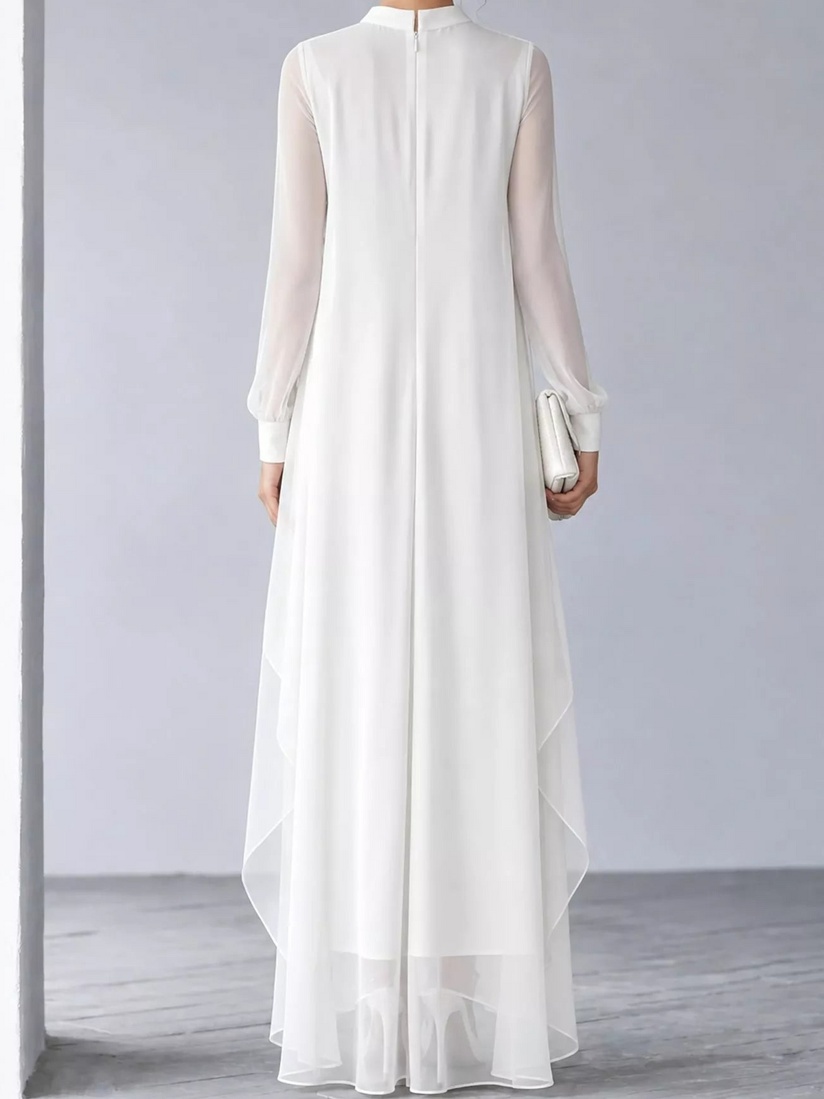Back view of white chiffon maxi dress with sheer sleeves and layered hem
