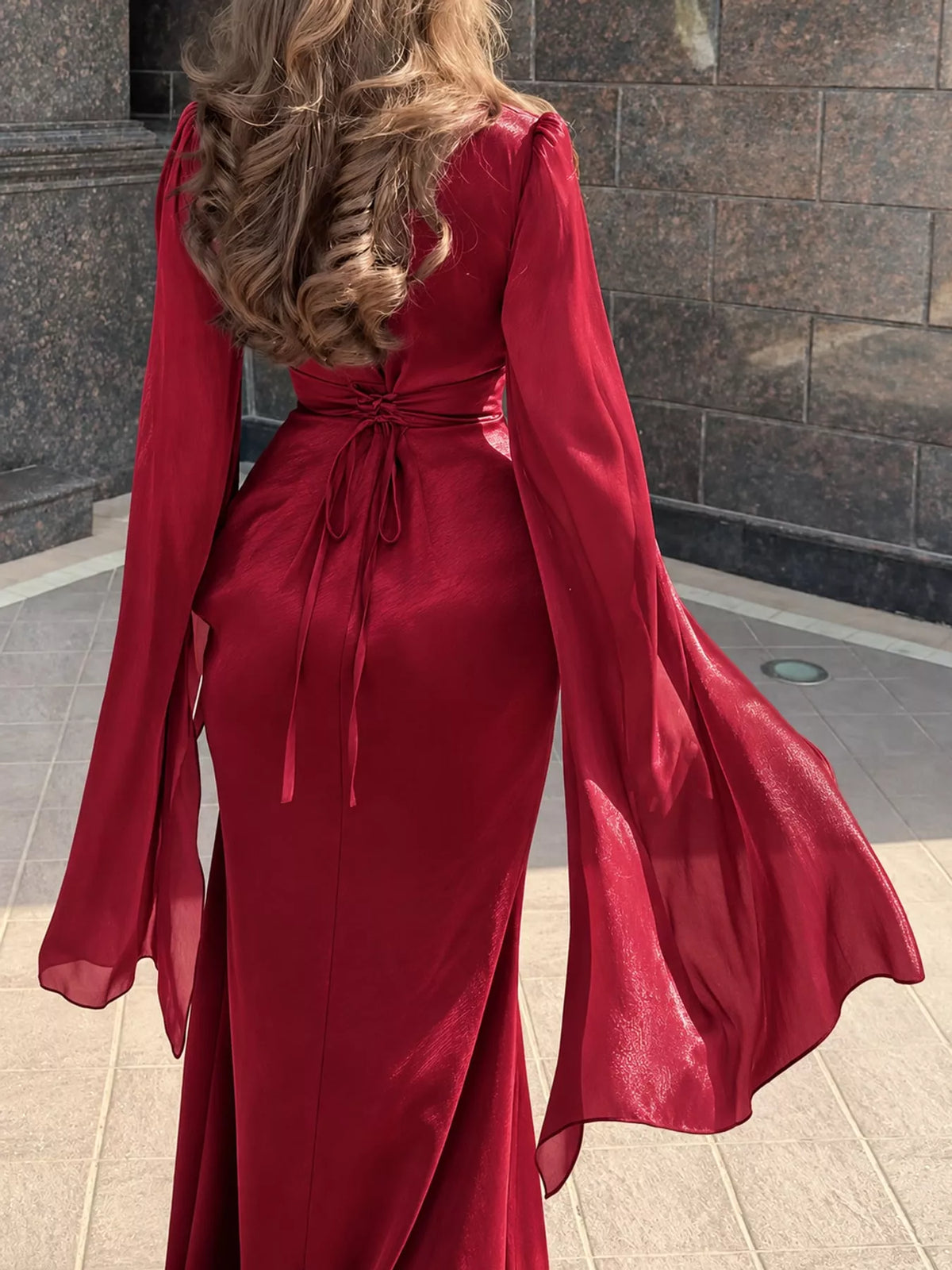 Back of the red maxi dress with a waist tie and sheer flared sleeves