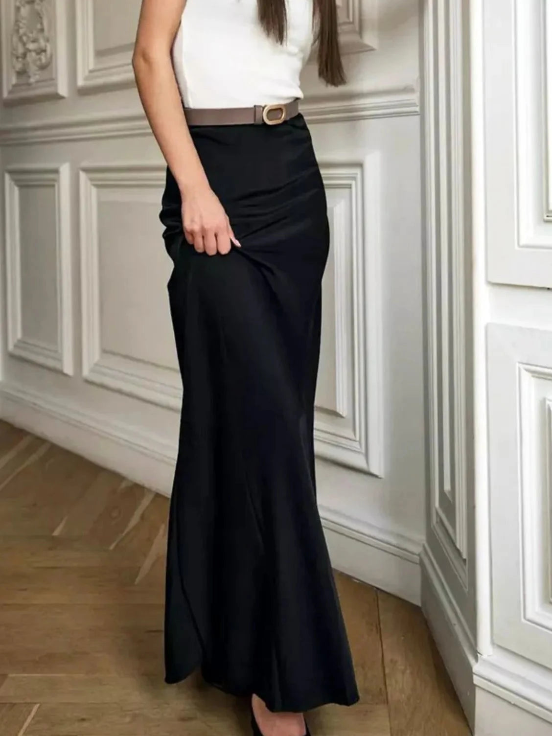 Black high-waisted maxi skirt with curved seam lines and fitted waist