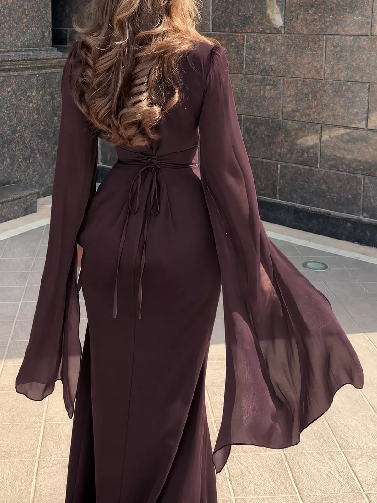 Burgundy maxi dress with a tied back waist and long sheer flare sleeves