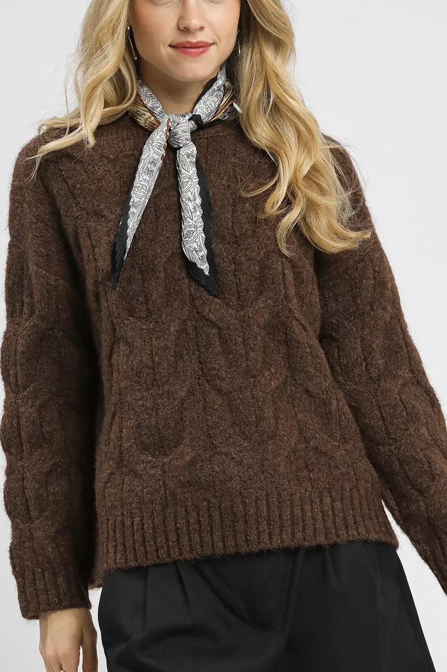 Brown cable-knit sweater with mock neck and gray patterned tie bow
