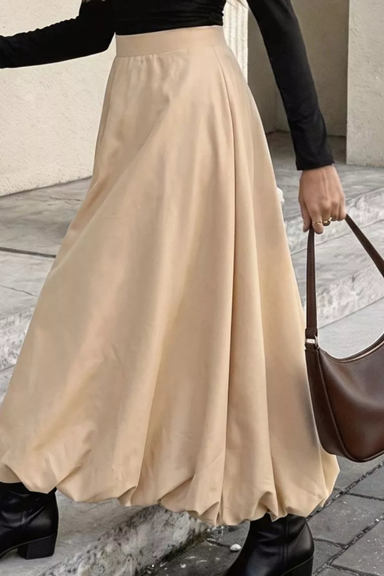 Tan A-line midi skirt with a smooth high waistband and voluminous hem.