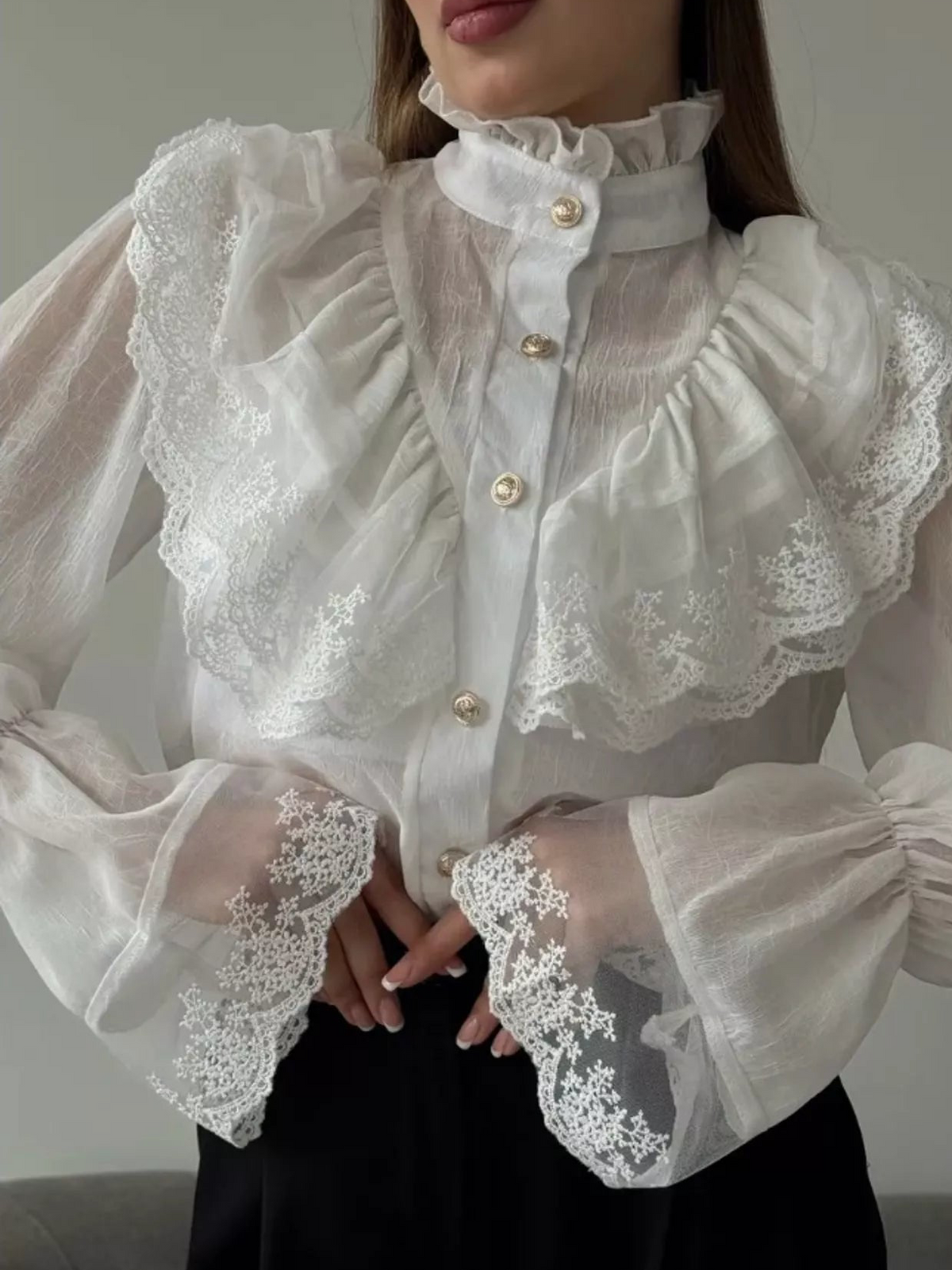 White sheer shirt with a lace flounce bib, pearl-style buttons and ruffled collar