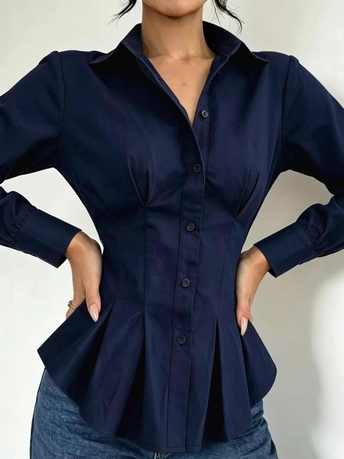 Navy button-down peplum blouse with fitted waist, long sleeves, front button placket