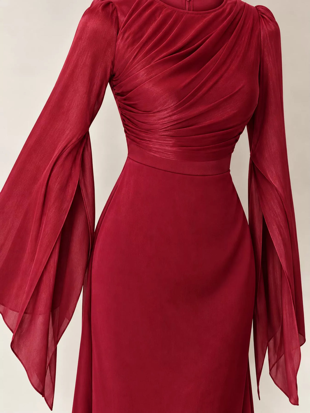 Close-up of the red dress's ruched bodice and sheer flared sleeves