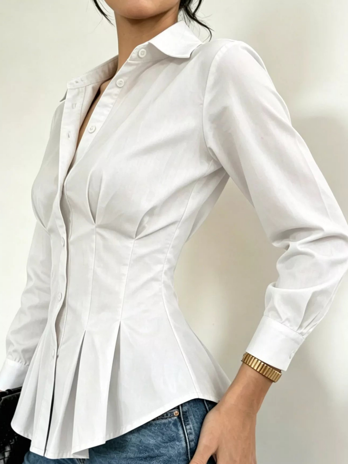 White button-down peplum blouse with fitted waist, angled side view, long sleeves