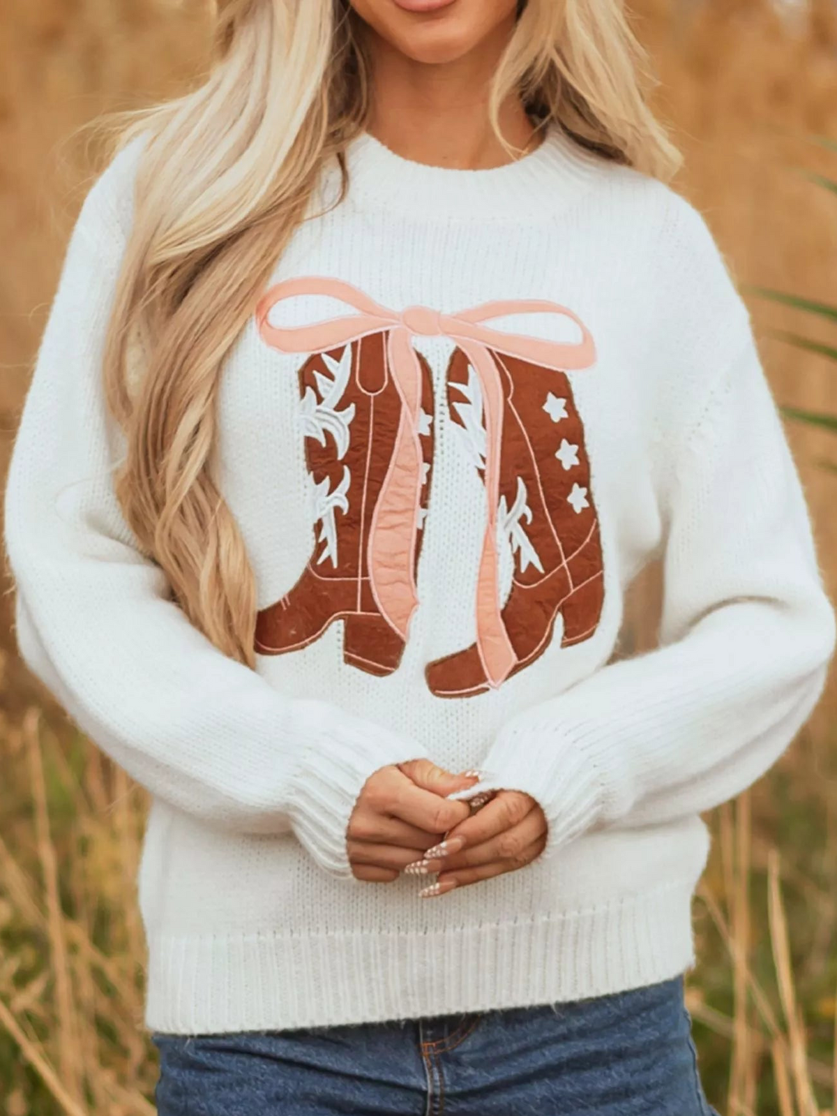 White embroidered graphic sweater with bow boots design and ribbed hem