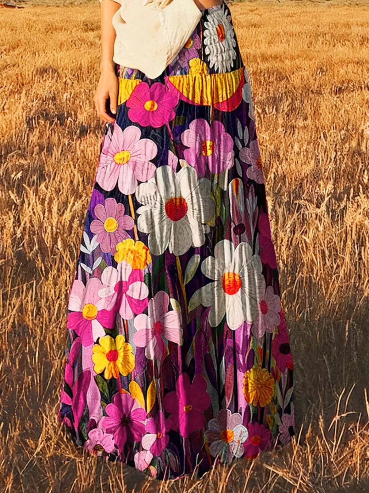 High-waisted maxi skirt with pink and yellow florals on dark fabric, tiered design