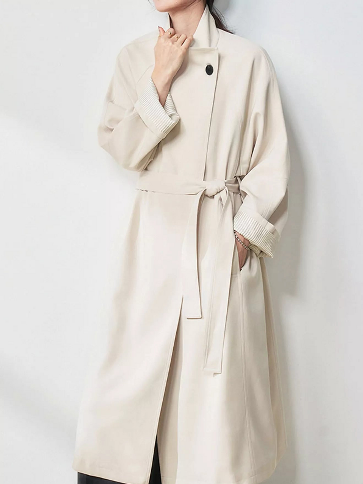 Beige longline coat with asymmetric front, tied belt, and wide sleeves