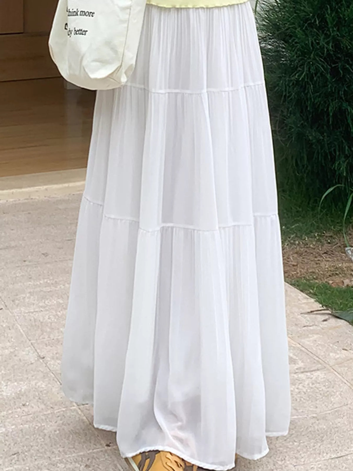 White tiered pleated maxi skirt with elastic waist and flowing panel tiers