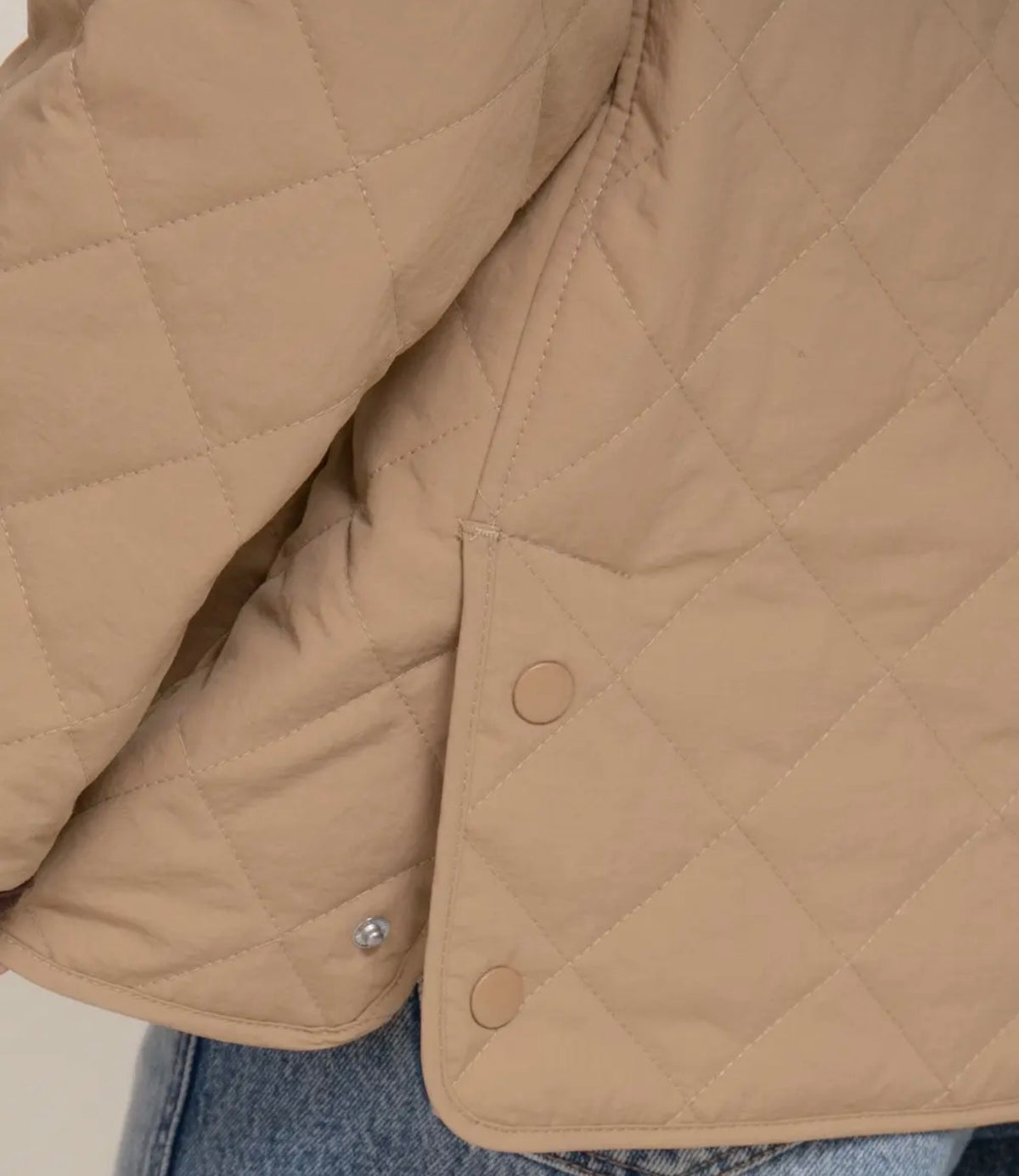 Tan quilted puffer jacket with snap-button front and stand-up lapel collar
