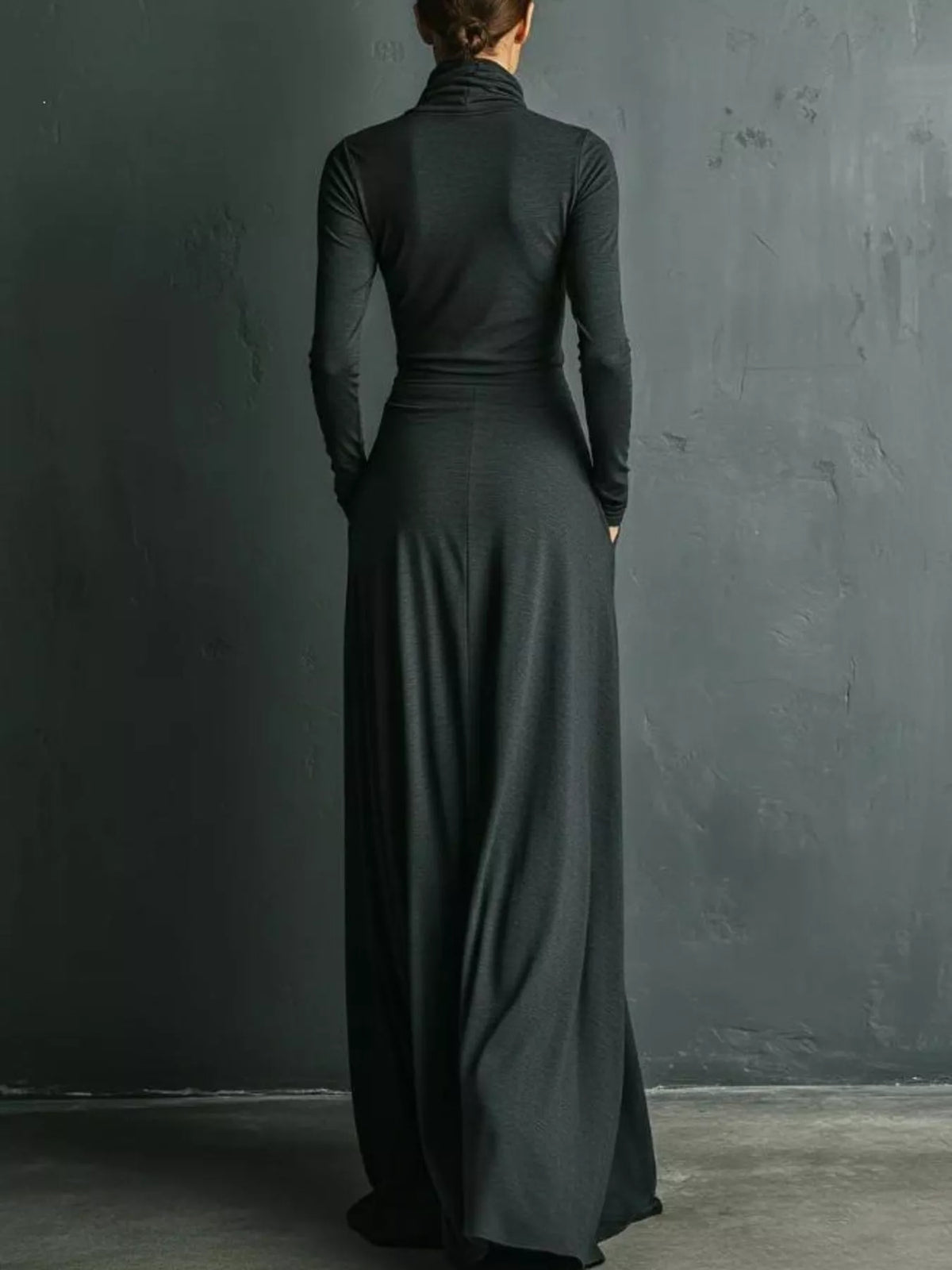 Back view: draped turtleneck maxi dress in dark gray with long sleeves and fitted bodice
