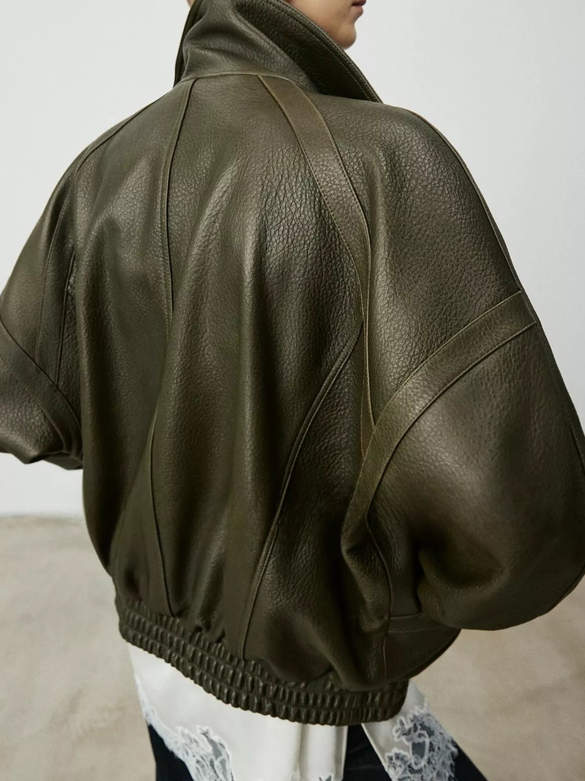 Dark green leather down jacket back with gathered yoke and ribbed elastic hem