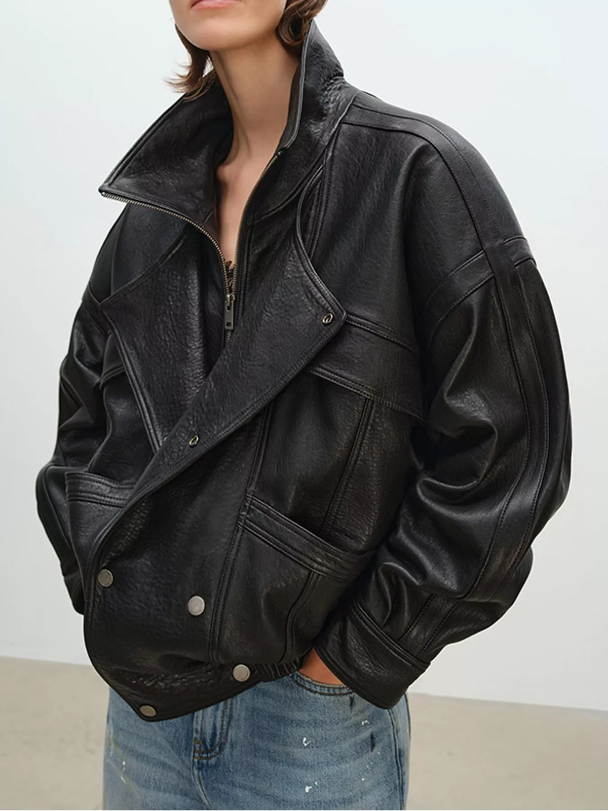 Black leather jacket with diagonal crossbody pocket, zip front, side view