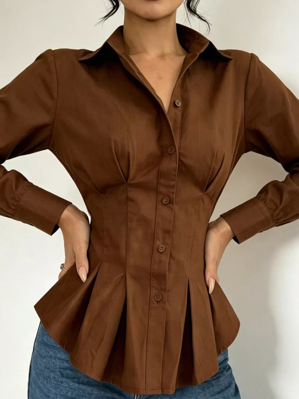 Dark brown button-down peplum blouse with fitted waist, long sleeves, curved hem flare