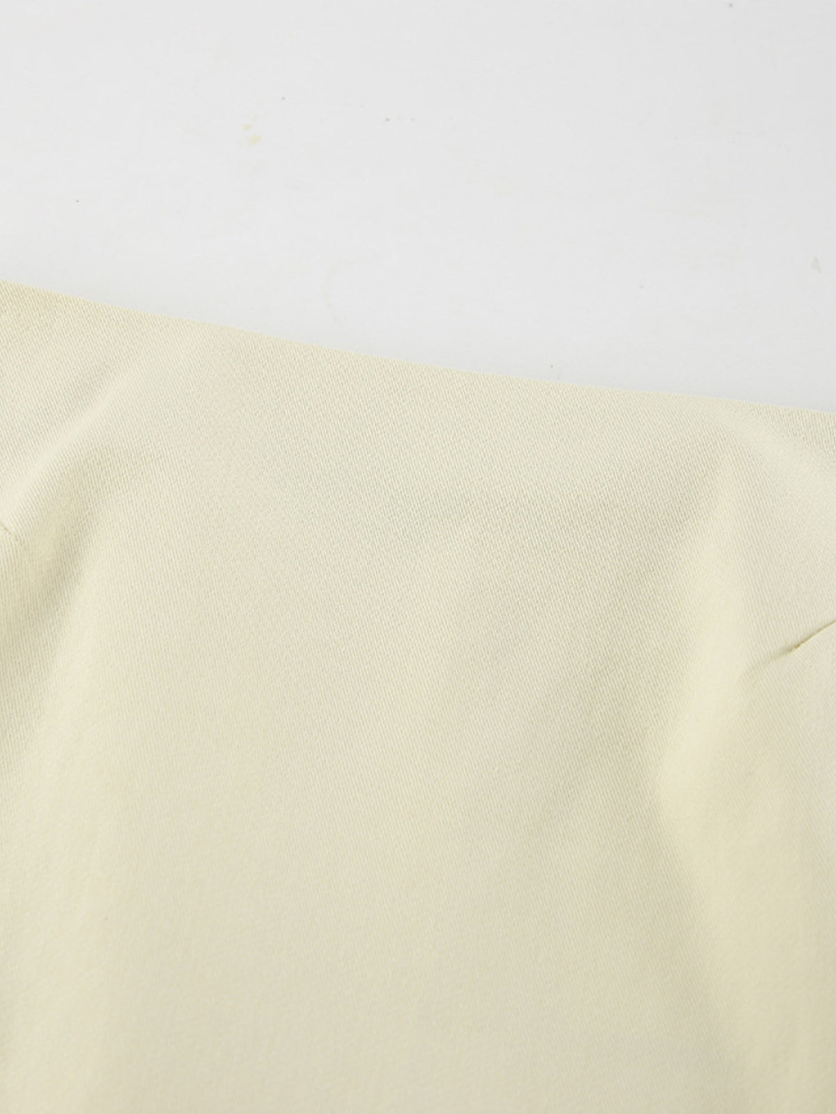 Close-up of beige midi skirt fabric and a small side slit.