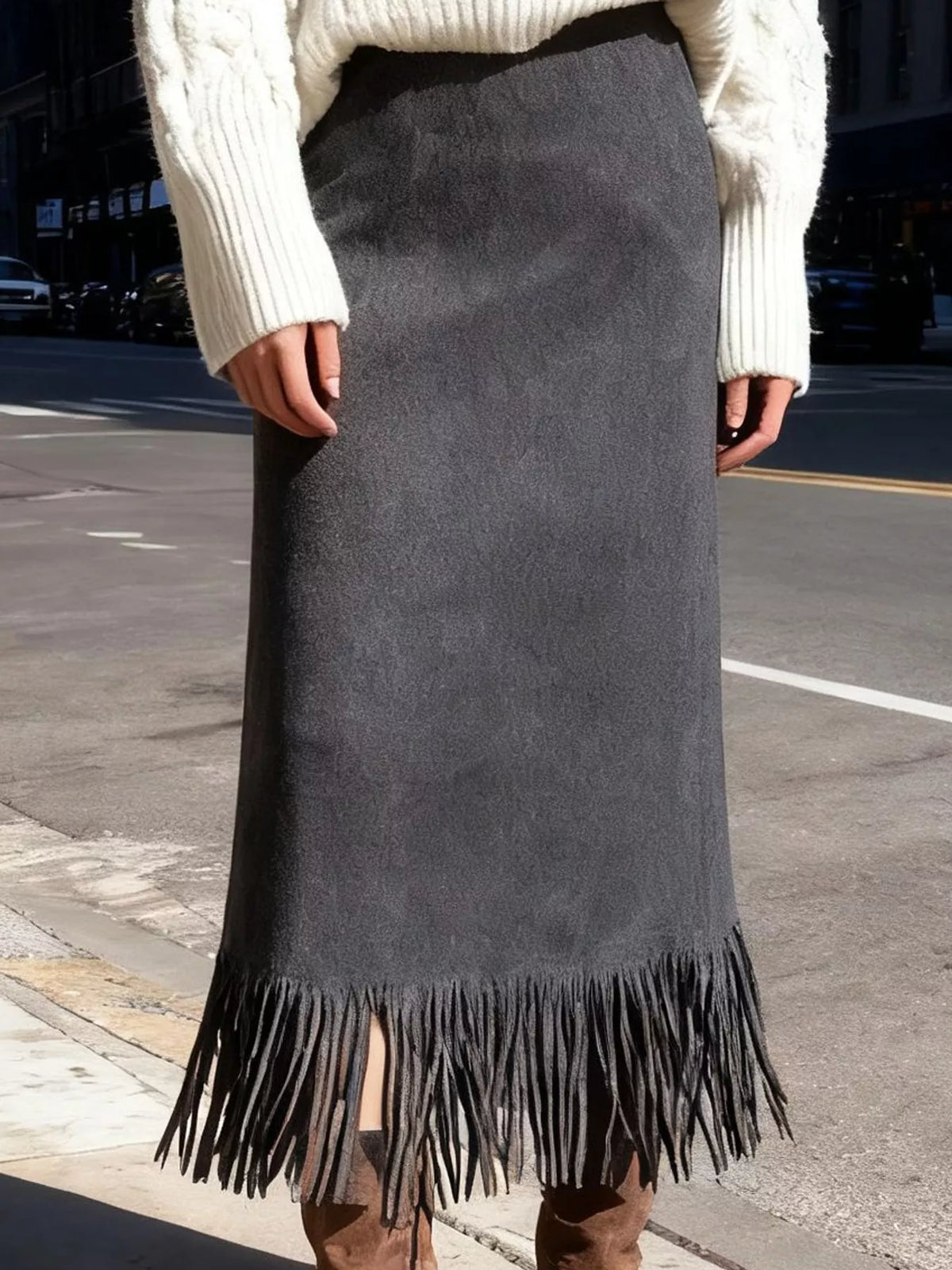 Dark gray high-waisted midi skirt with fringe hem, worn with a sweater