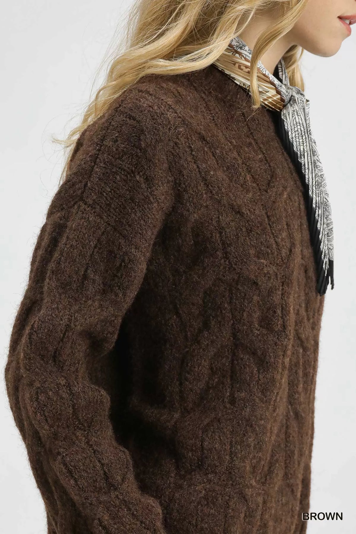 Brown cable-knit sweater with gray patterned scarf detail at shoulder