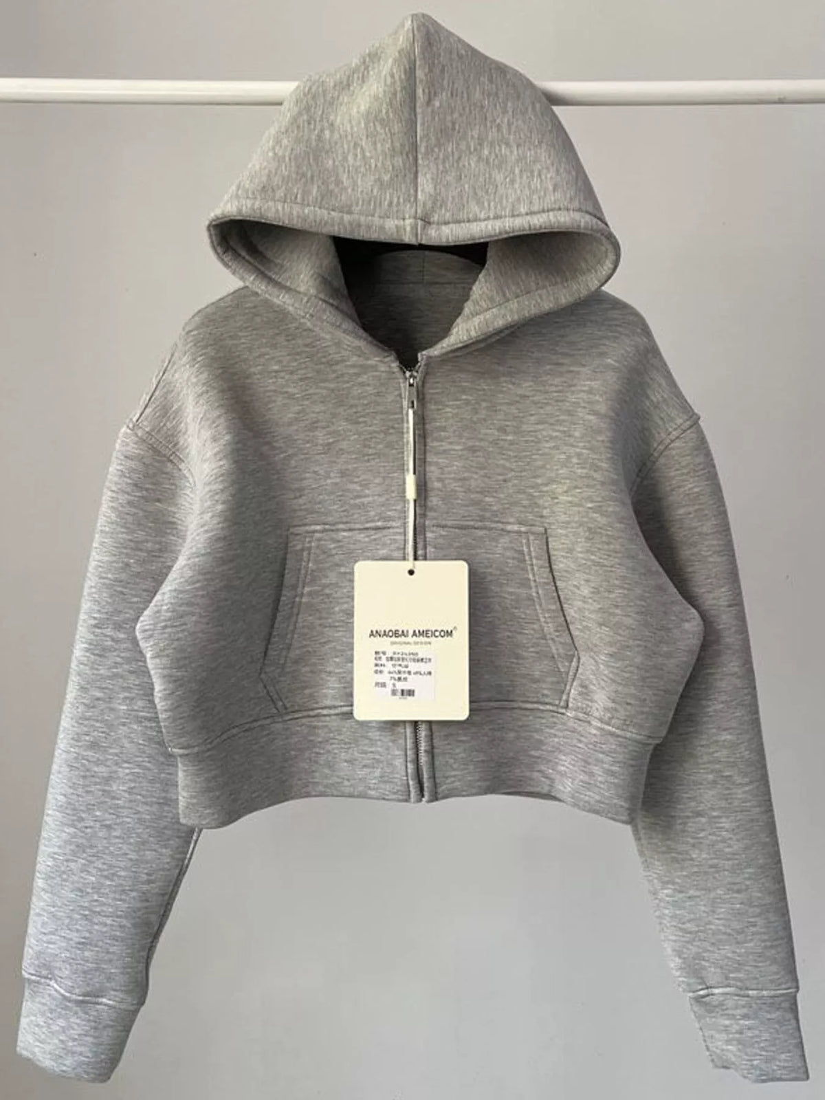 Light gray cropped zip-up hoodie with hood, front zipper, and kangaroo pocket.