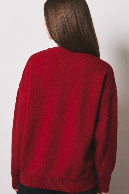 Back view of red knit sweater with ribbed hem and cuffs