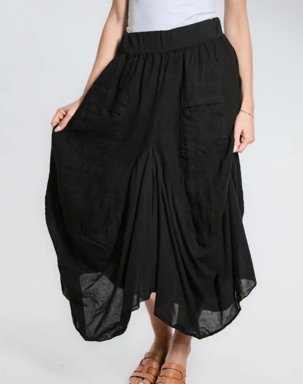 Black linen-cotton skirt with deep pockets, ruched tiers, wide elastic waist and draped hem