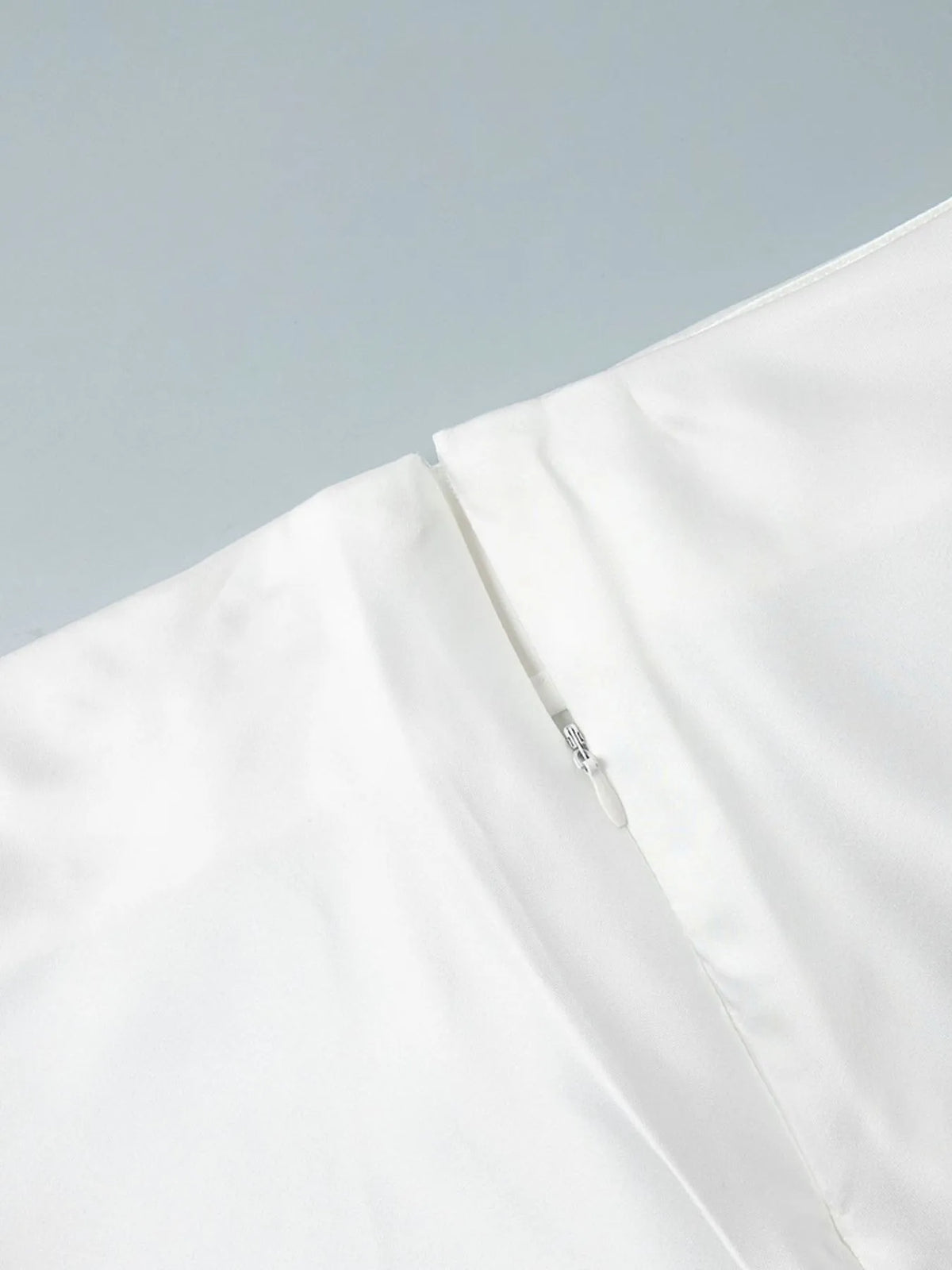White high-waisted maxi skirt with visible inner tag at the side seam.