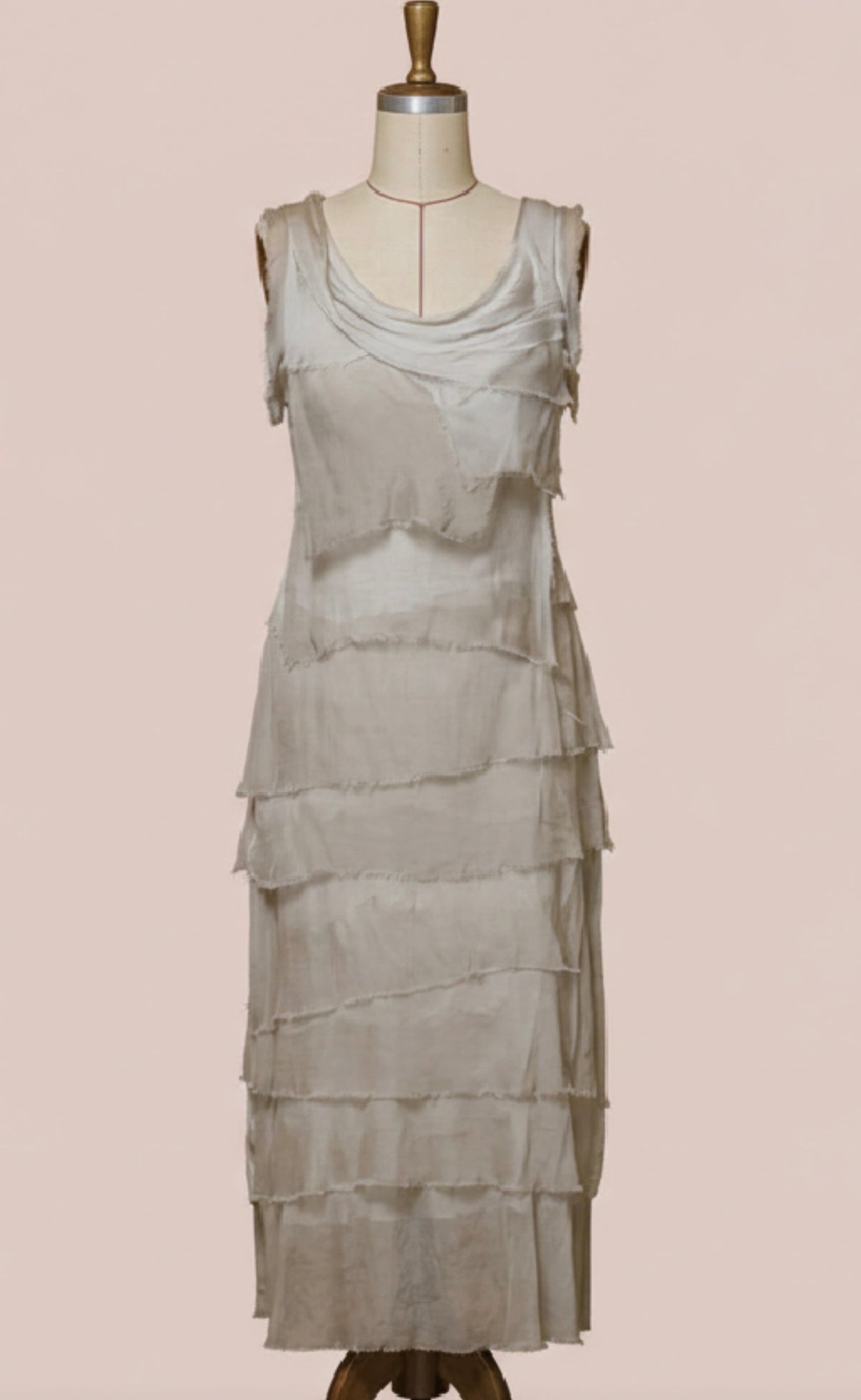 Beige tiered ruffle silk sleeveless dress on mannequin, midi length