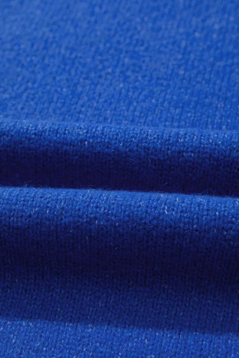 Royal blue knit sweater fabric and seam texture close-up