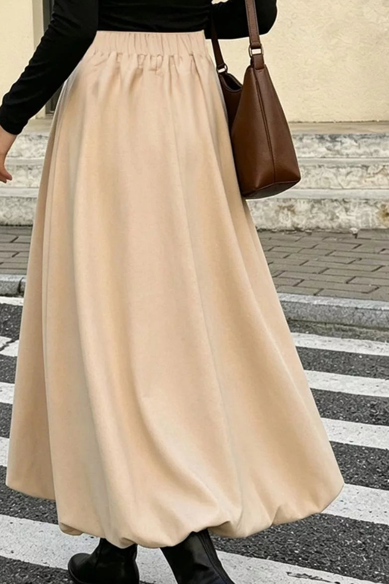 Back view of the tan midi skirt, showing its gathered waistband and flowing A-line shape.