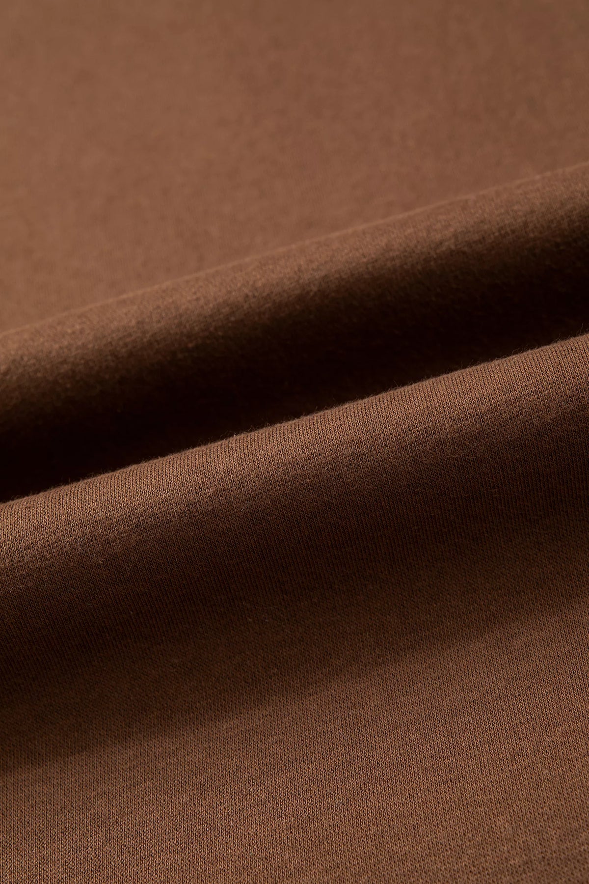 Close-up of dark brown sweatshirt fabric with smooth knit texture