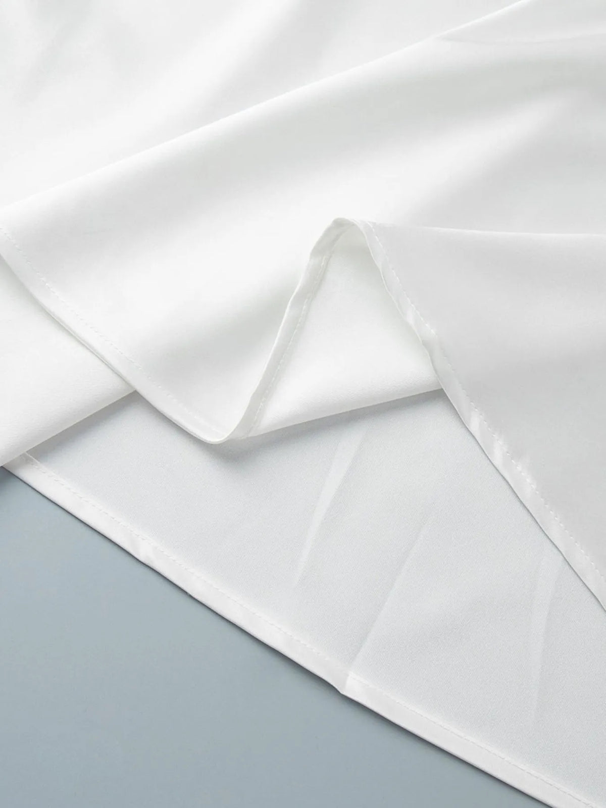 White high-waisted maxi skirt fabric folds with layered look at the hem edge.