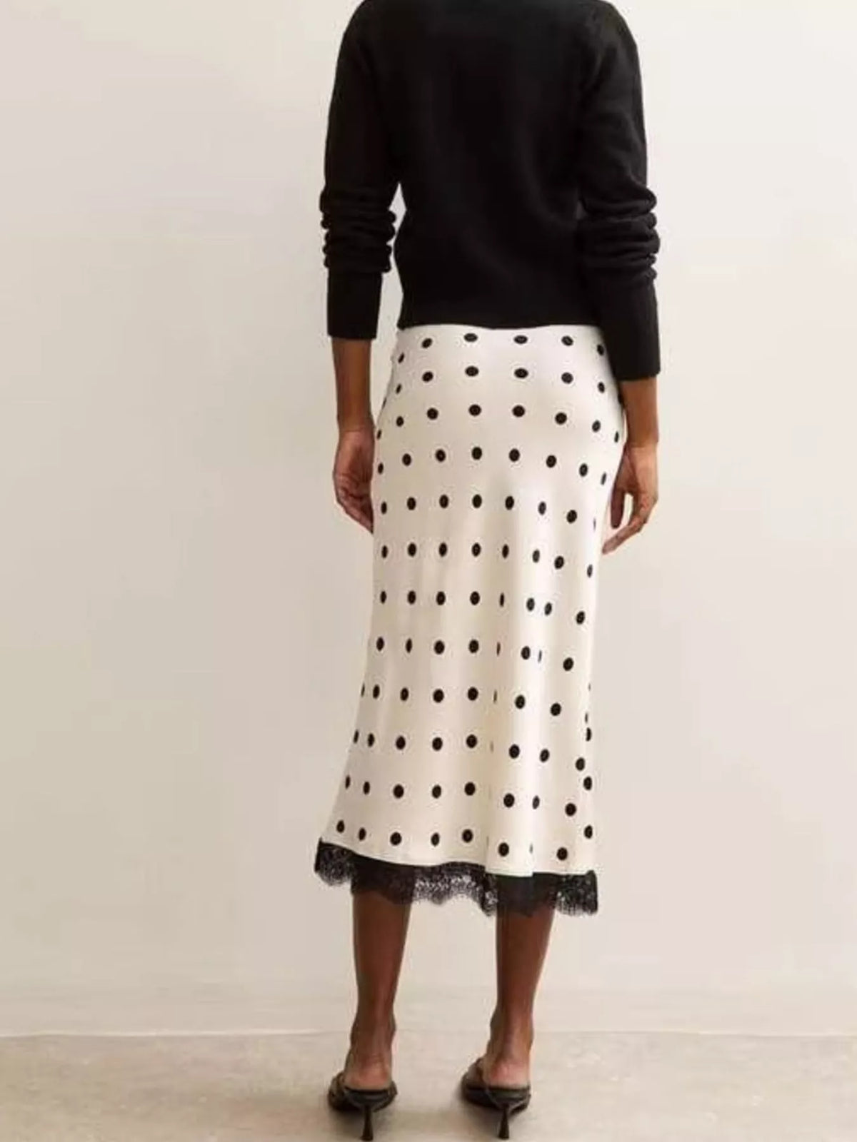 Back view of the white midi skirt with black dots and lace trim.