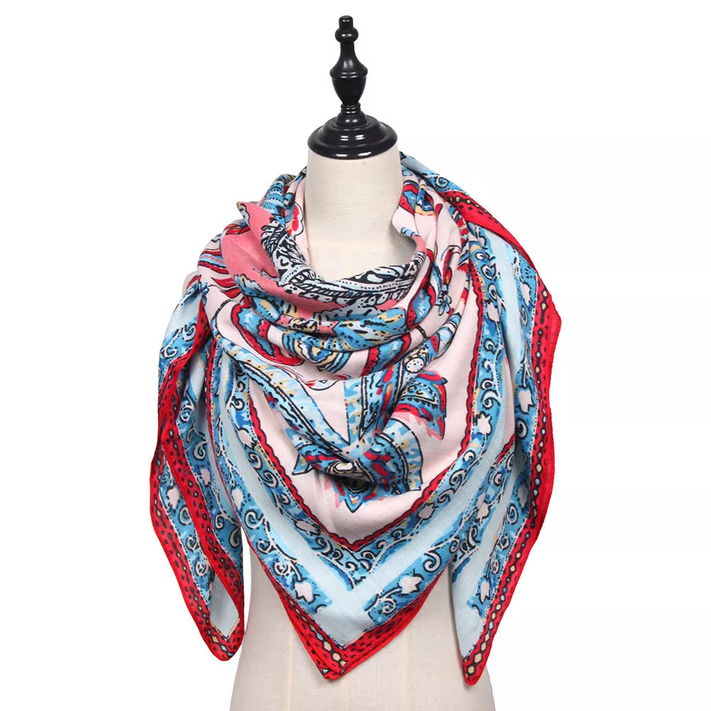 Square silk-feel scarf draped on a mannequin, with a red, blue and pink paisley print.