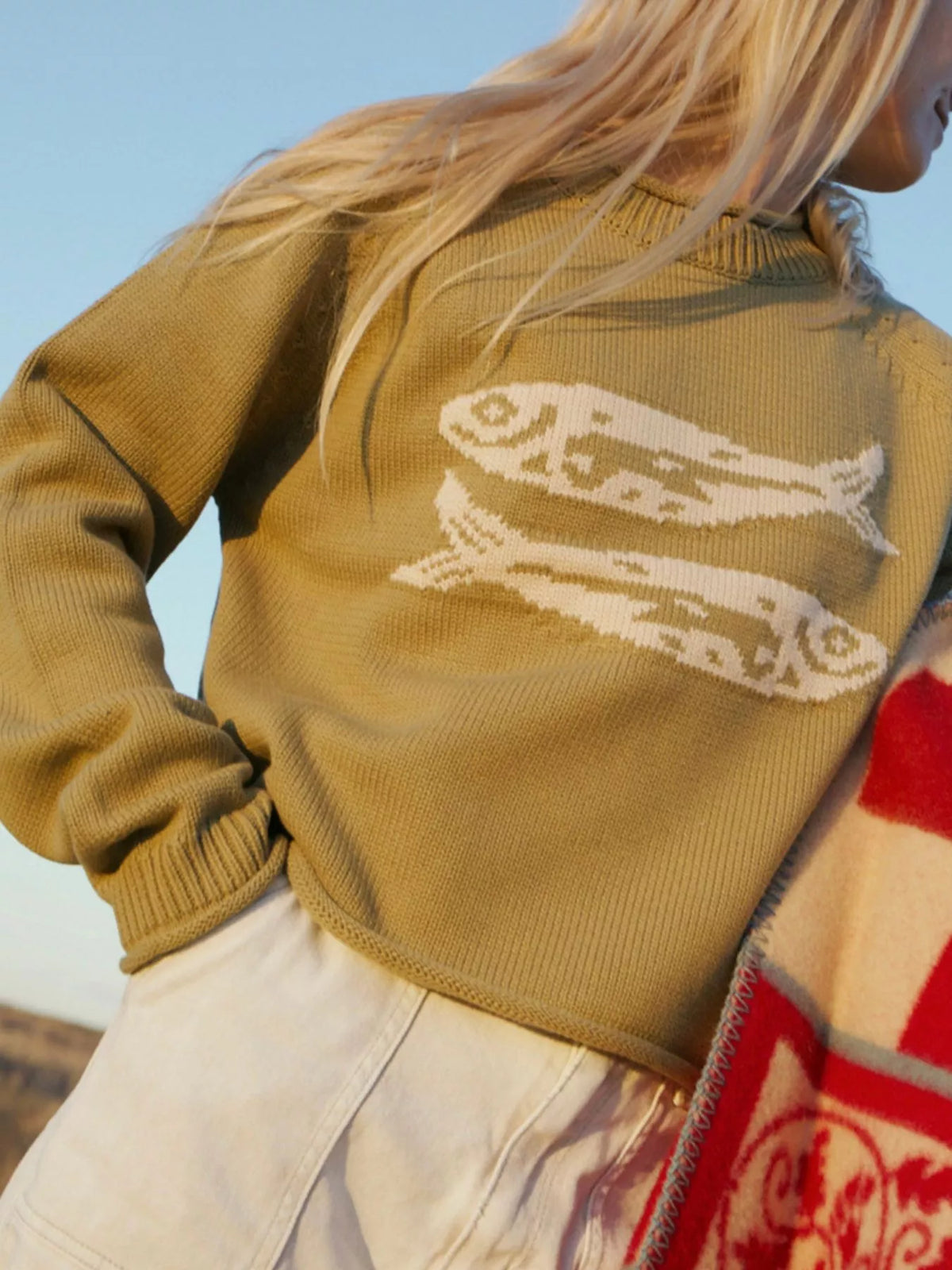 Tan crew neck knit sweater with white fish motif and ribbed hem