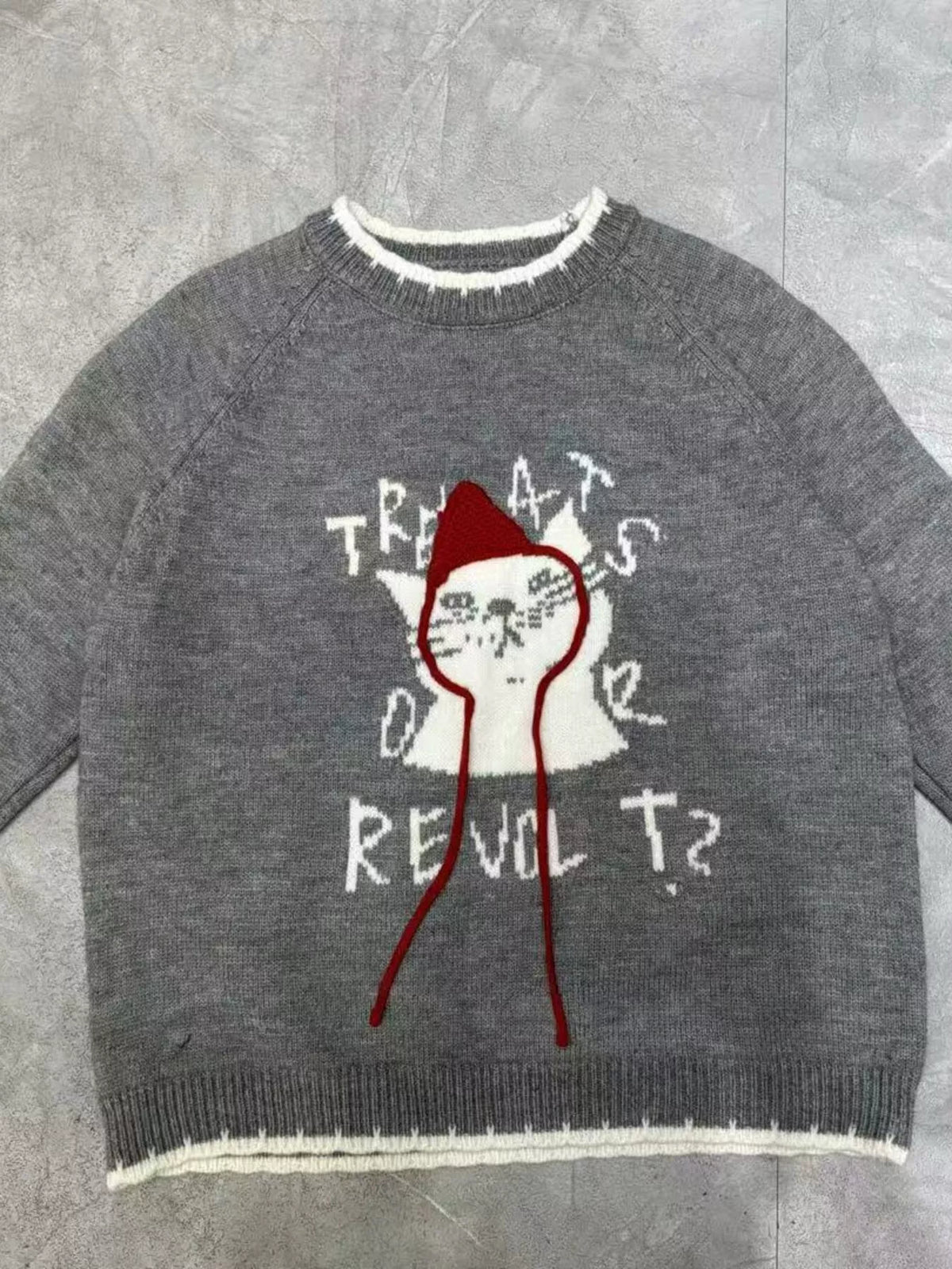 Gray raglan sweater with cat face print, red accents, and ribbed cuffs
