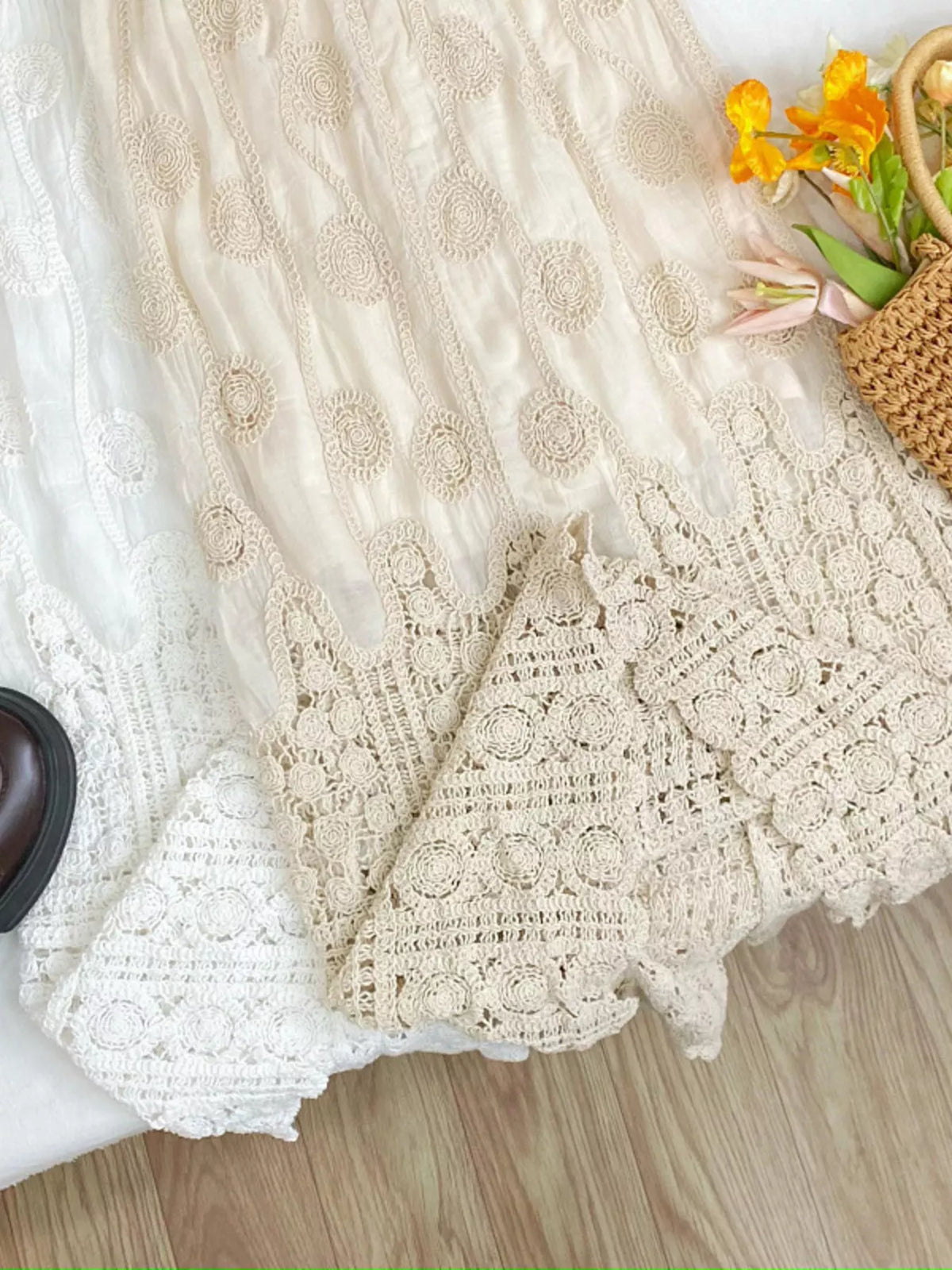 Close view of lace midi skirt hems with circular crochet patterns in white and apricot