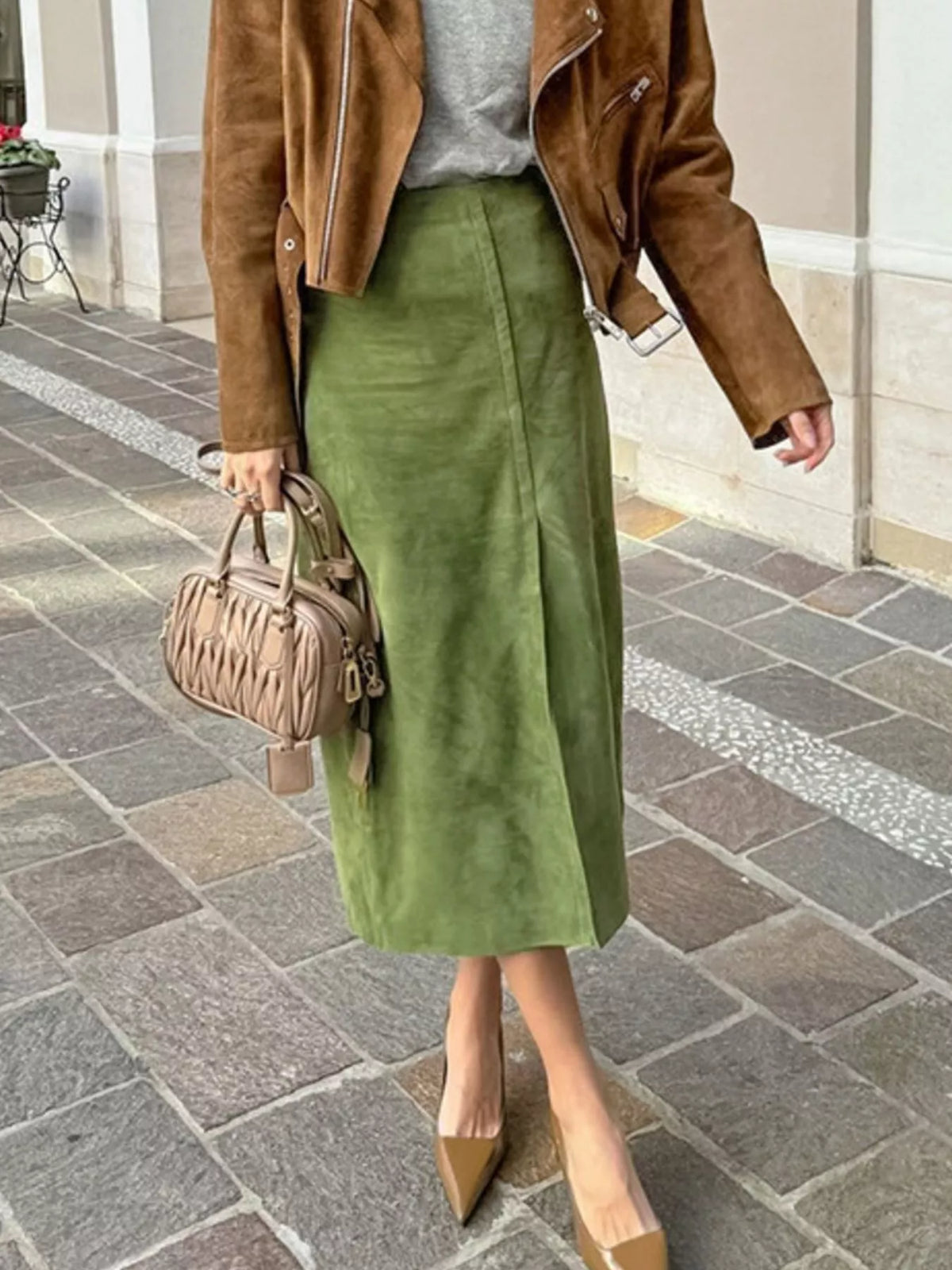 Matcha green midi skirt shown on a model, with a straight silhouette and side slit.