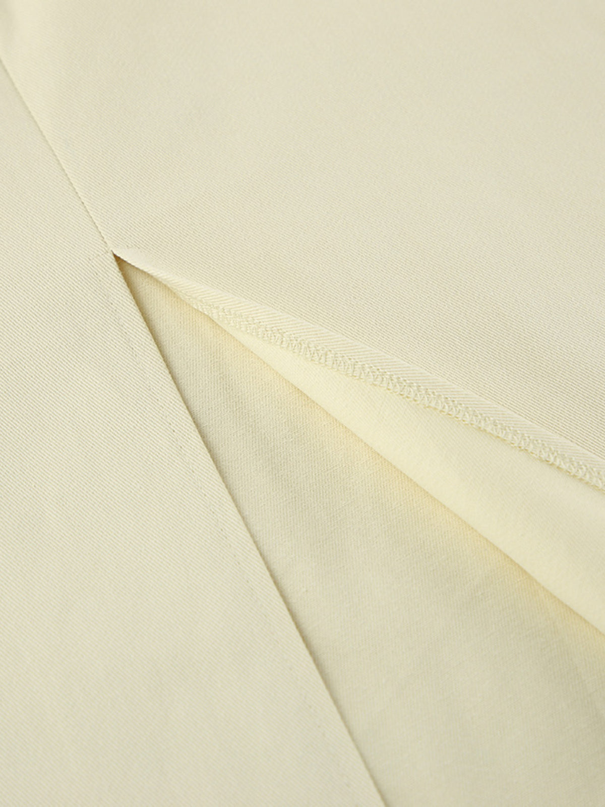 Beige slit midi skirt fabric close-up showing the overlapping slit and stitching.