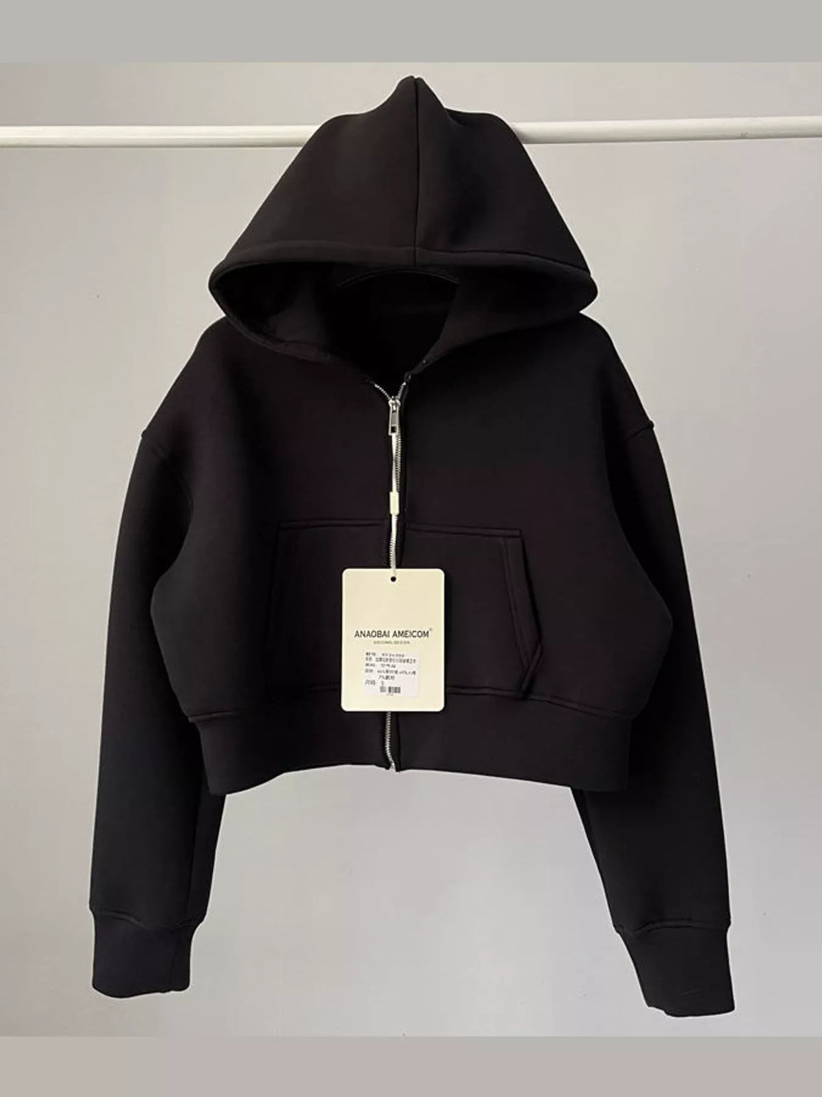 Black cropped zip-up hoodie with hood, front zipper, and kangaroo pocket.