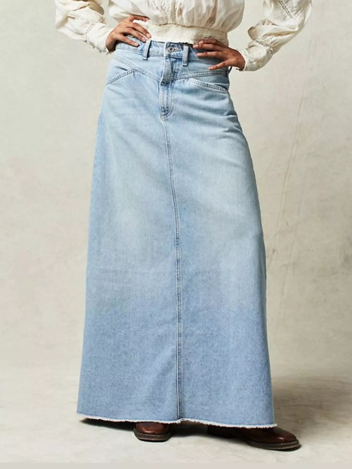 Light blue raw-hem denim maxi skirt with waistband buttons and stitched seams