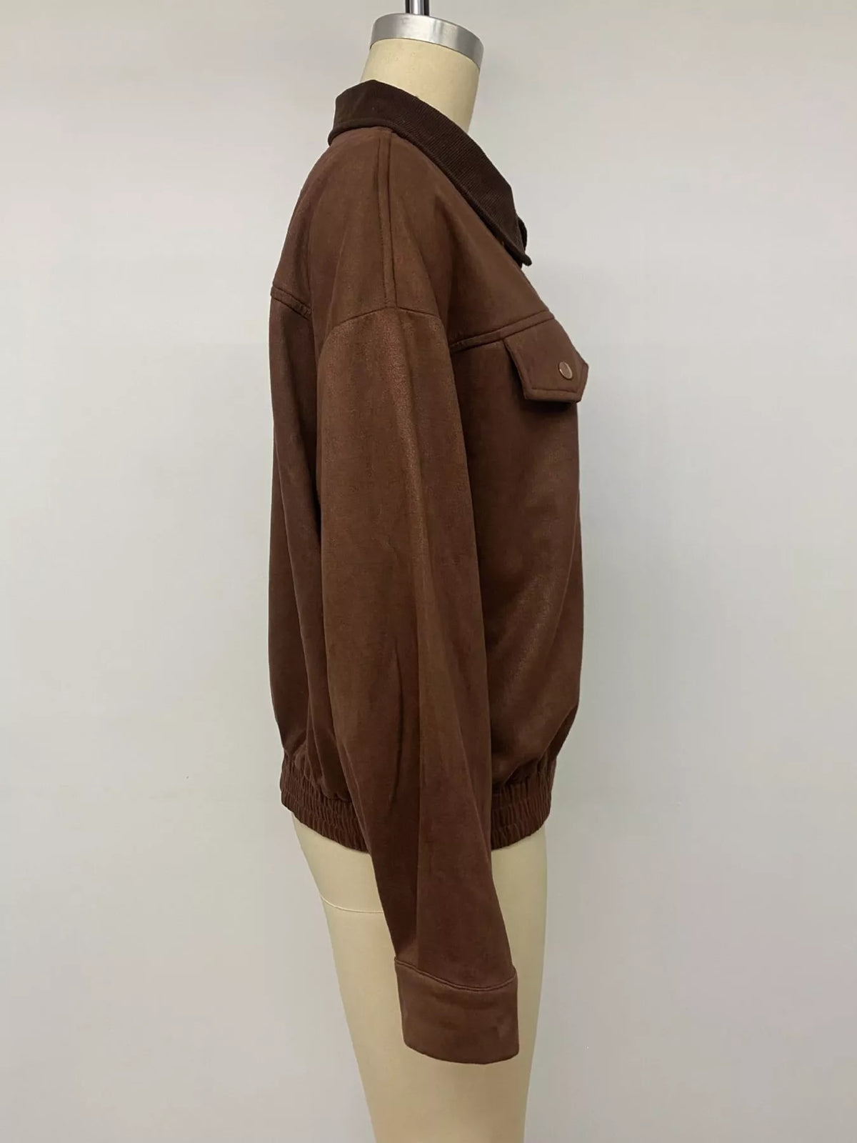 Brown zip-up jacket side view with snap cuff and ribbed hem