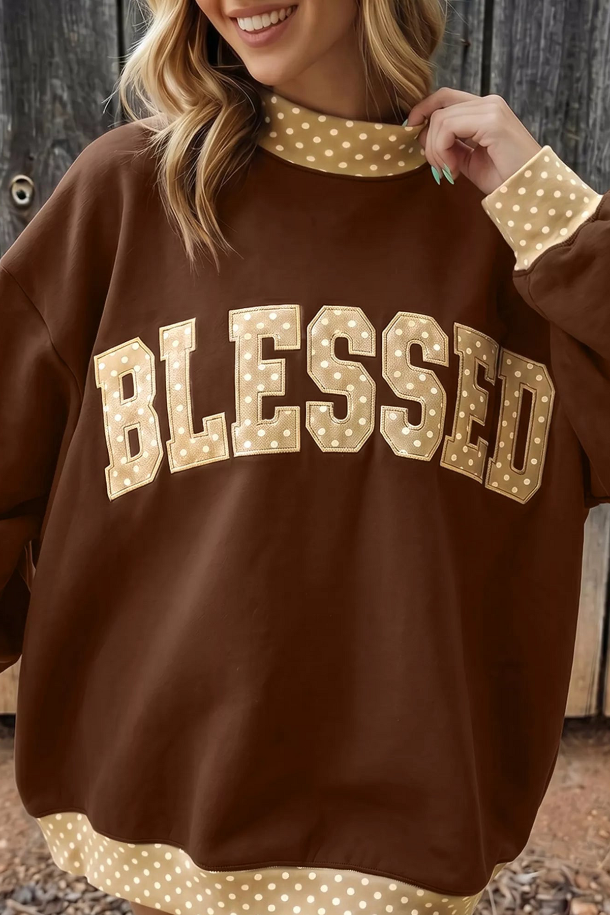 Dark brown high-neck sweatshirt with polka-dot trim and 'BLESSED' letter graphic