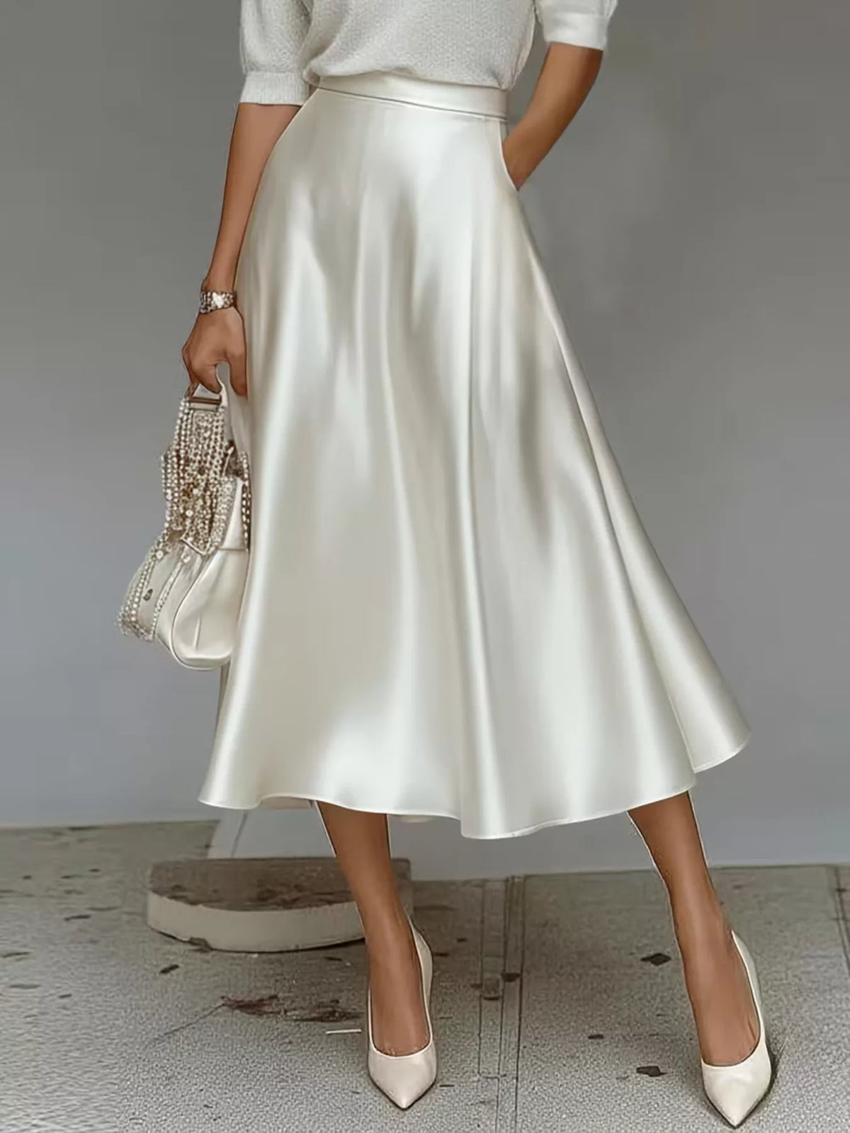 White satin midi skirt shown from the front, with a flared hem and side pocket.