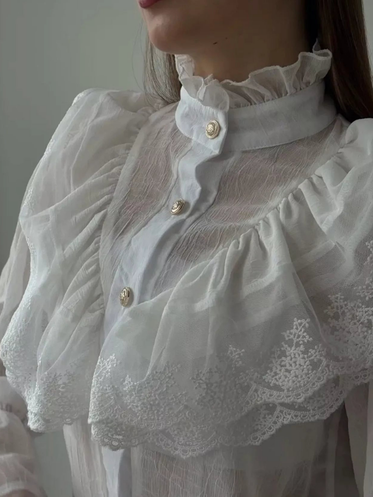 Close-up of the shirt's ruffled high collar, gold-tone buttons and scalloped lace bib