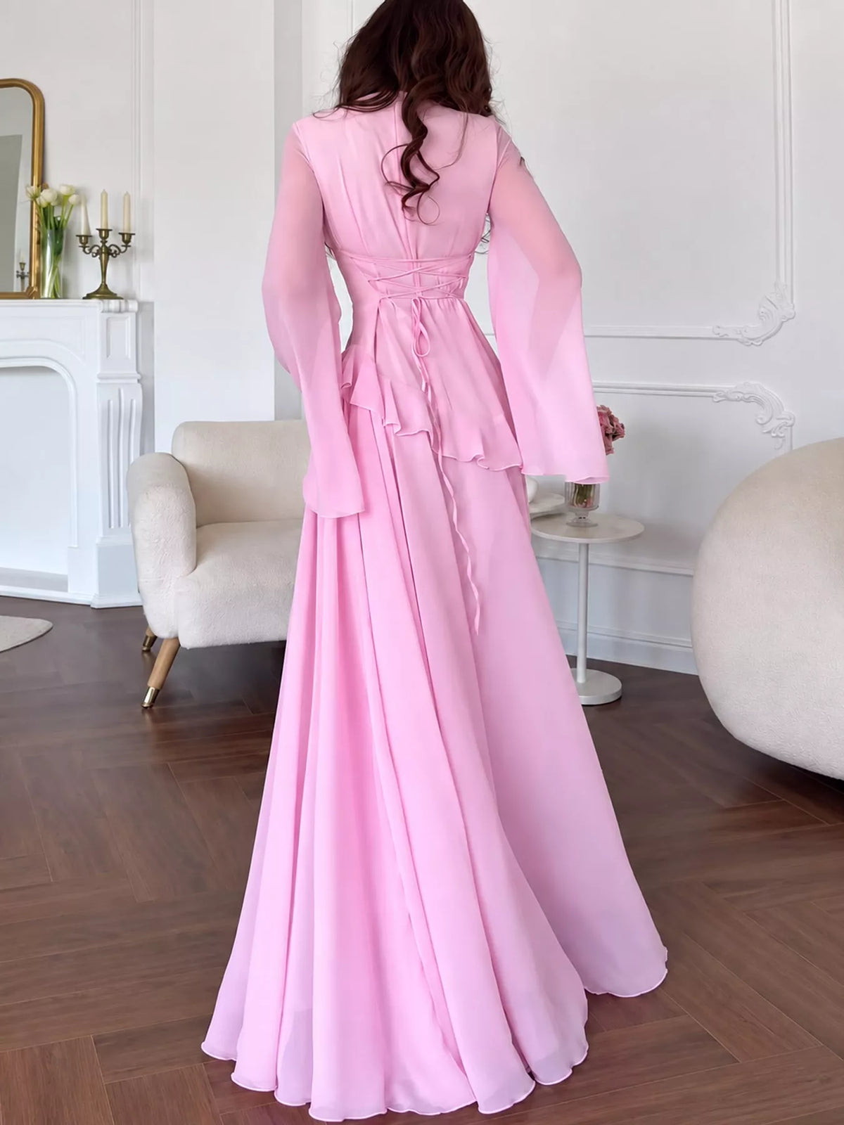 Light pink maxi dress with lace-up back and long sleeves plus tiered ruffle waist