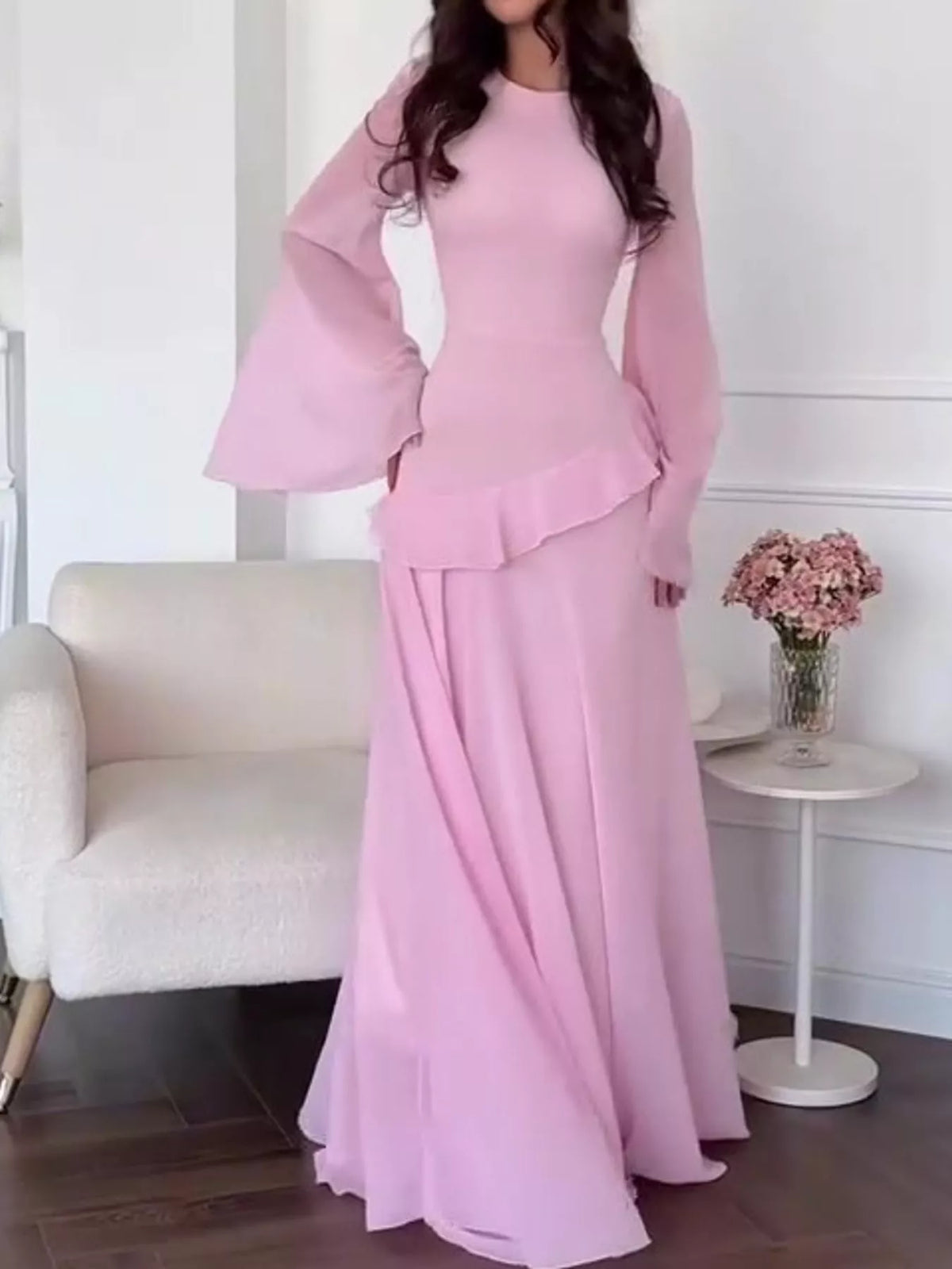 Light pink maxi dress with fitted bodice and layered ruffle hem at mid-calf