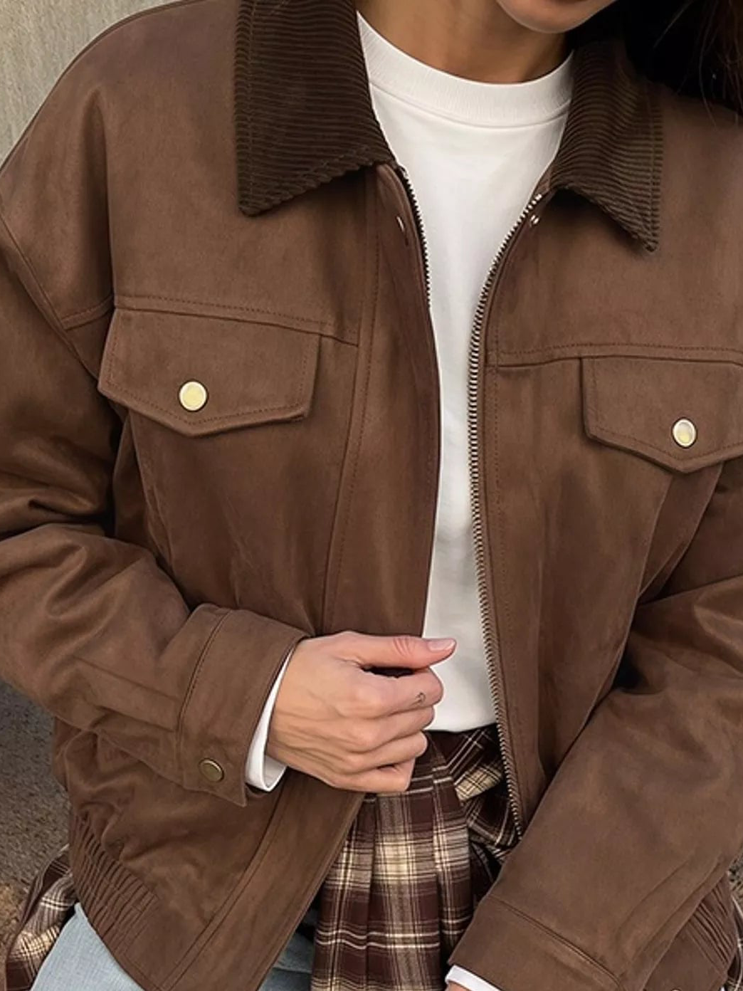 Brown zip-up jacket close-up with gold snap flap pockets and full zipper