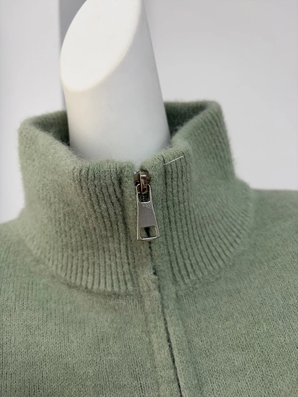 Close-up of the cardigan's ribbed mock neck and metal zipper pull