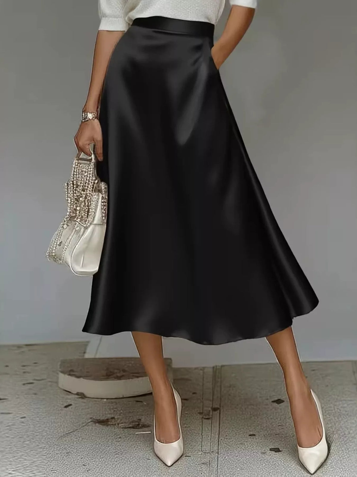 Black satin midi skirt with a high waist and flared A-line shape.