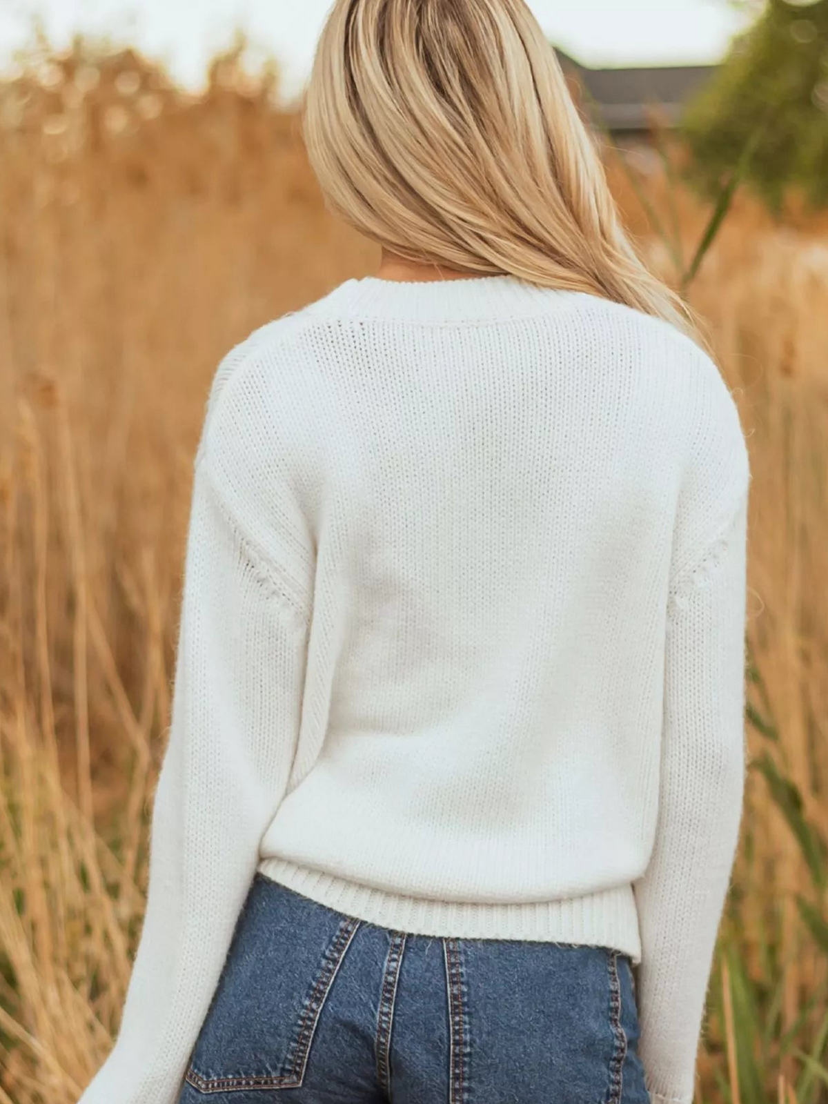 White drop-shoulder sweater with ribbed crew neck, shown from the back